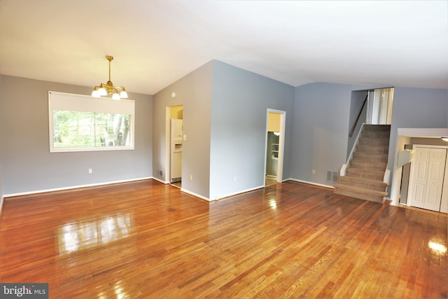 unfurnished living room featuring lofted ceiling, hardwood / wood-style floors, and a notable chandelier