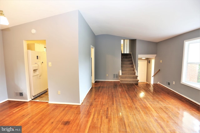 unfurnished living room featuring wood-type flooring and lofted ceiling