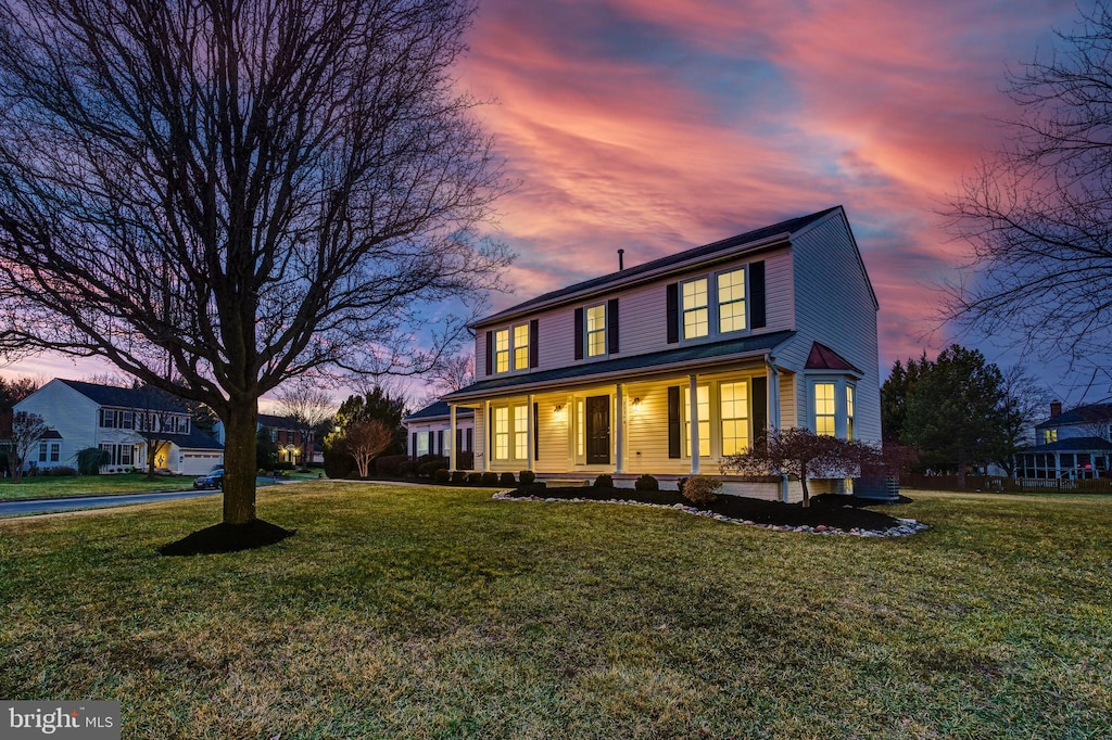 view of front of home with covered porch and a lawn