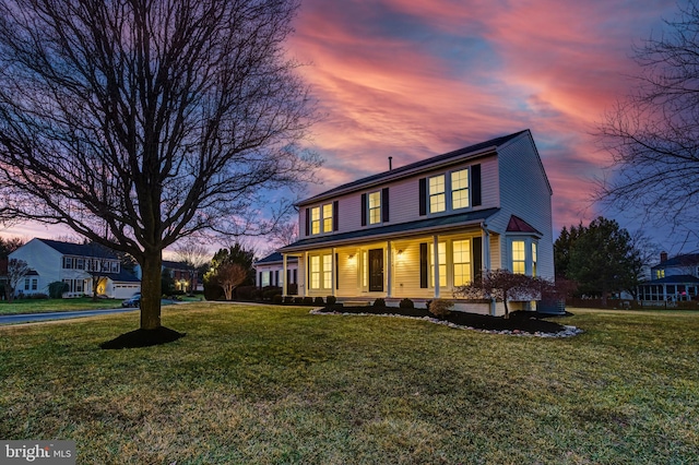 view of front of home with covered porch and a lawn