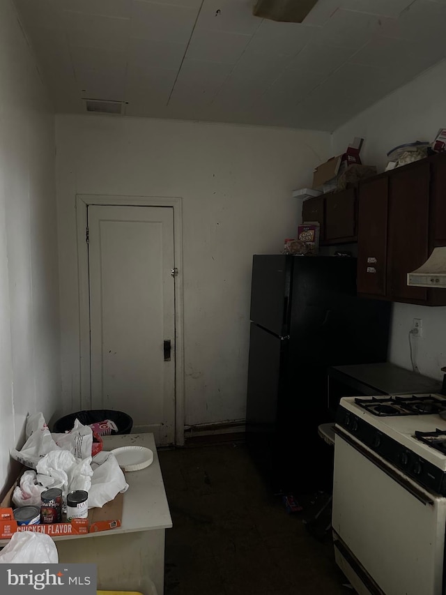 kitchen with black refrigerator, extractor fan, and white gas stove