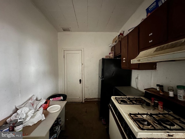 kitchen with black fridge, gas range gas stove, and dark brown cabinets