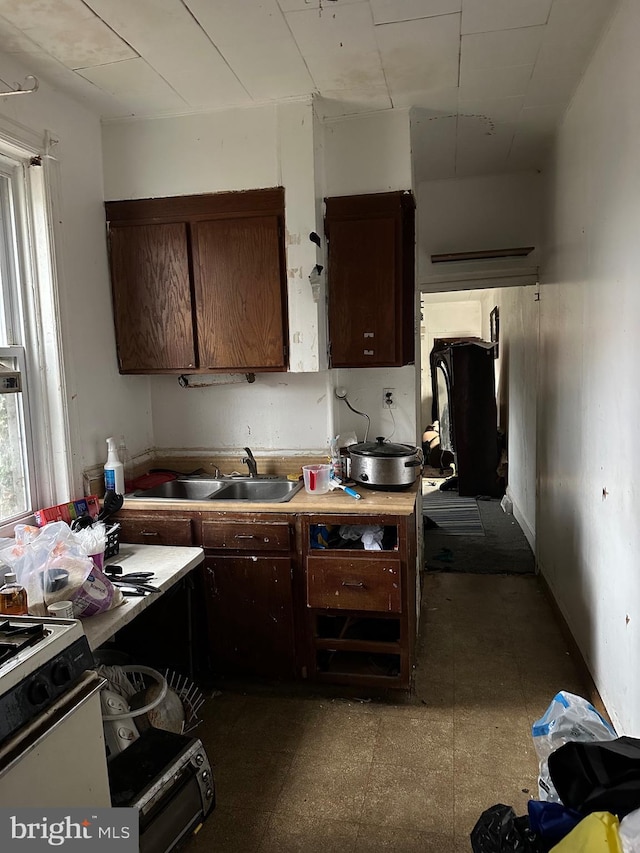 kitchen with sink, dark brown cabinets, and gas range gas stove