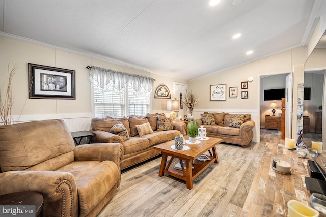 living room featuring lofted ceiling, ornamental molding, and light hardwood / wood-style flooring