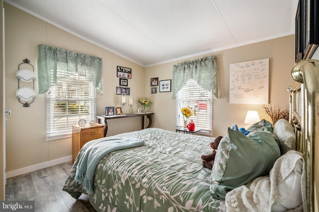 bedroom with crown molding, vaulted ceiling, and light hardwood / wood-style floors