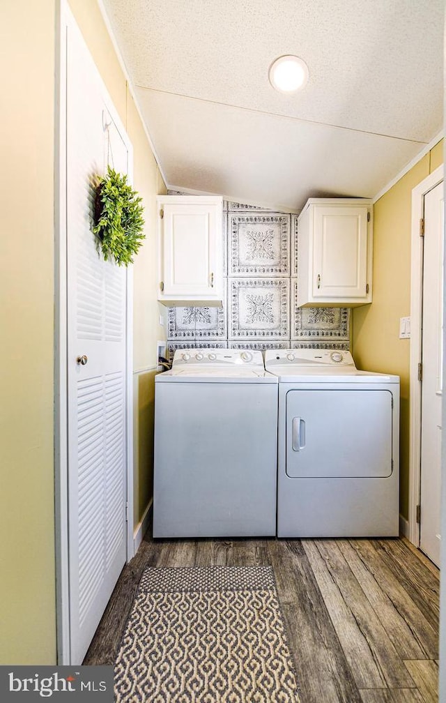 laundry area with crown molding, cabinets, washer and dryer, a textured ceiling, and dark hardwood / wood-style flooring