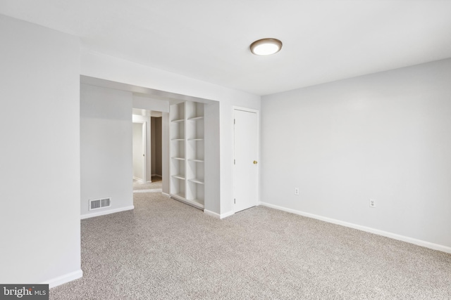 carpeted spare room with baseboards and visible vents