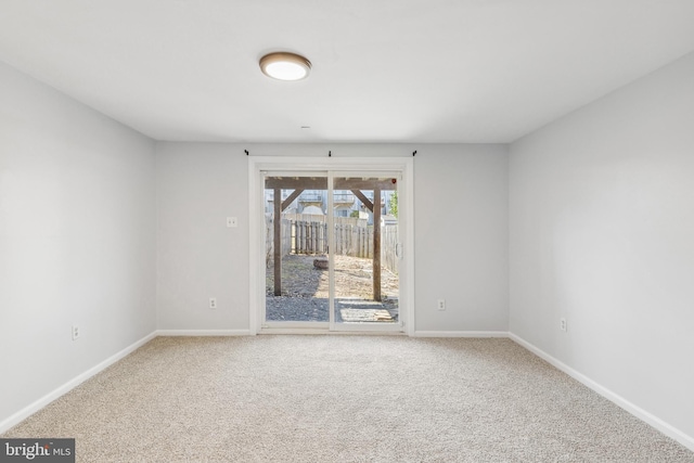 carpeted empty room featuring baseboards