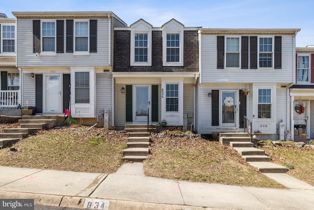 townhome / multi-family property featuring a shingled roof and mansard roof