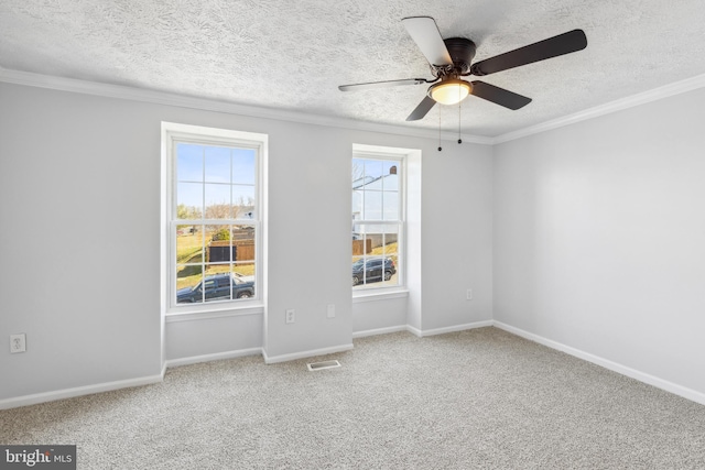 spare room featuring ornamental molding, carpet, visible vents, and baseboards