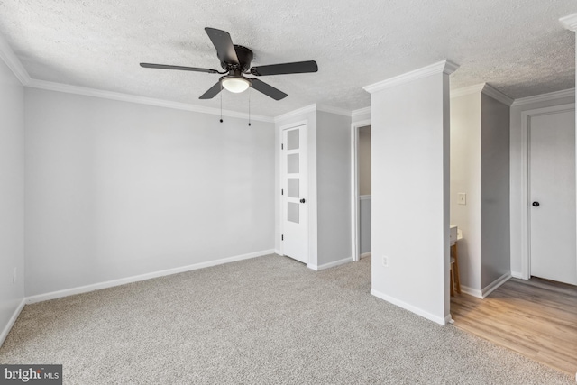 unfurnished bedroom featuring baseboards, carpet floors, a textured ceiling, and crown molding