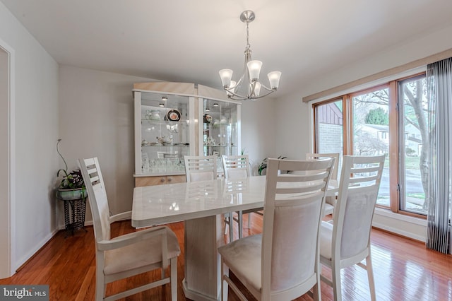 dining room with an inviting chandelier, plenty of natural light, and hardwood / wood-style floors