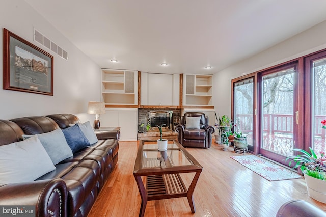 living room featuring a fireplace and light wood-type flooring