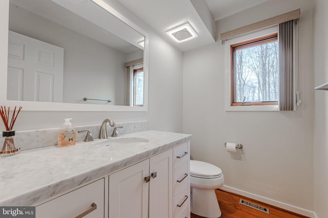 bathroom featuring vanity, wood-type flooring, and toilet