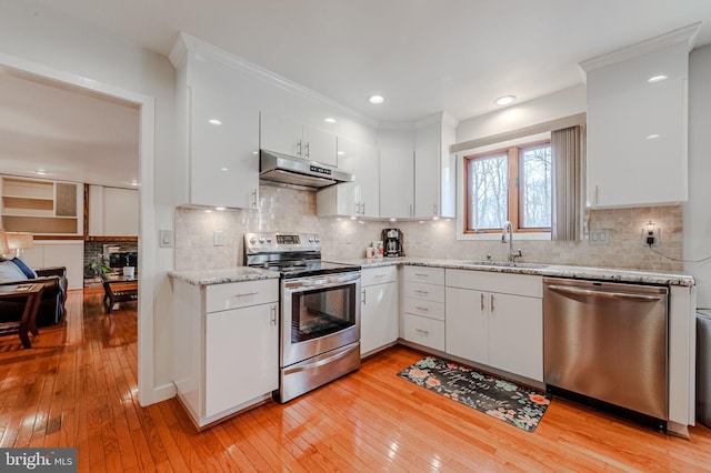 kitchen featuring sink, light hardwood / wood-style flooring, white cabinetry, stainless steel appliances, and tasteful backsplash