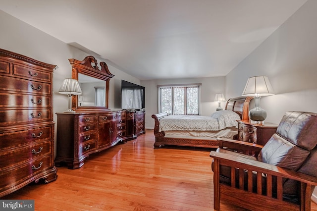 bedroom with lofted ceiling and light hardwood / wood-style floors