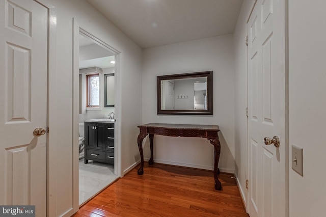 hallway featuring sink and light wood-type flooring