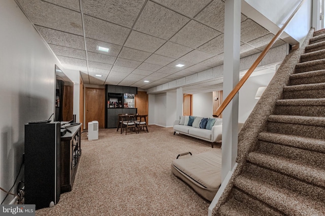 living room with a paneled ceiling and carpet flooring