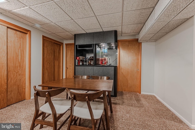 dining room featuring a paneled ceiling and carpet flooring