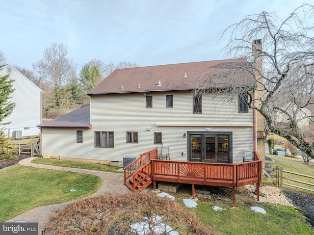 back of property with central AC unit, a yard, and a deck