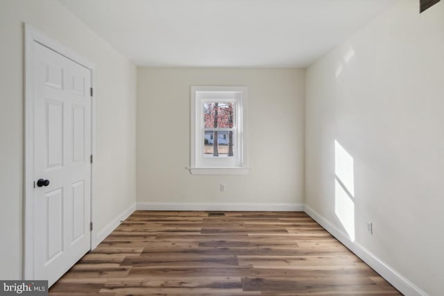 unfurnished room featuring baseboards and wood finished floors