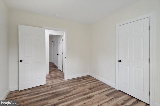 spare room featuring wood finished floors and baseboards