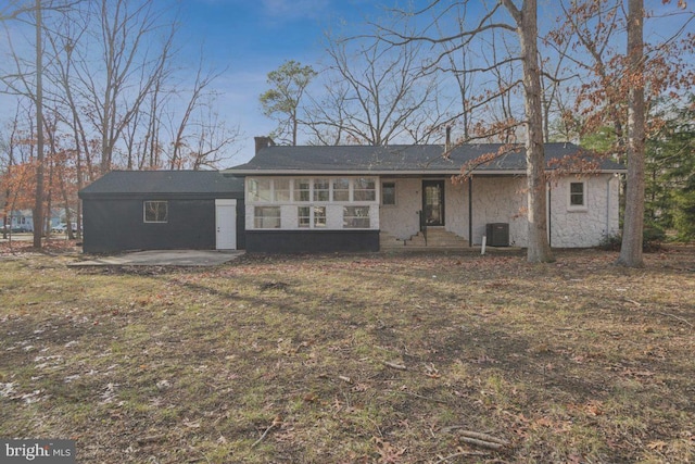 ranch-style home featuring a patio, central AC unit, a chimney, and stone siding