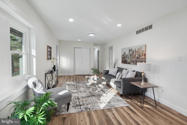 living room with recessed lighting, wood finished floors, visible vents, and baseboards