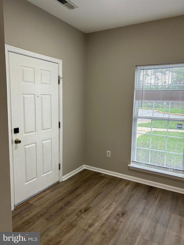 unfurnished room featuring dark hardwood / wood-style floors and a wealth of natural light