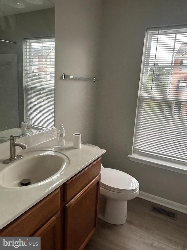 bathroom with hardwood / wood-style flooring, vanity, and toilet