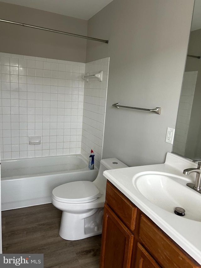 full bathroom featuring wood-type flooring, toilet, vanity, and tiled shower / bath