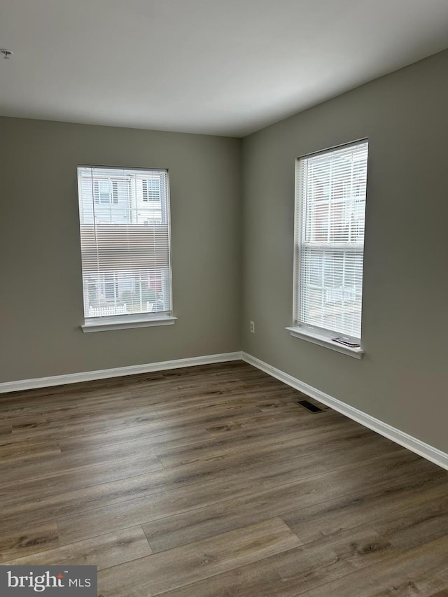 unfurnished room featuring hardwood / wood-style floors and a healthy amount of sunlight