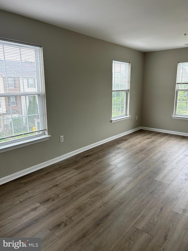 empty room featuring dark hardwood / wood-style flooring and plenty of natural light