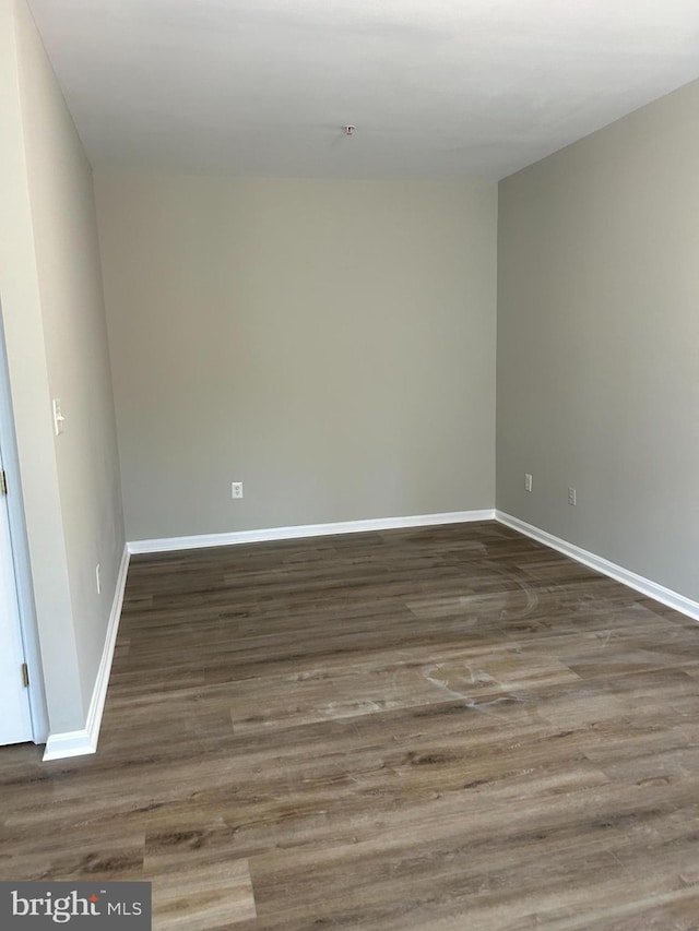 unfurnished room featuring dark wood-type flooring