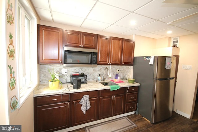 kitchen with sink, backsplash, stainless steel appliances, dark hardwood / wood-style floors, and a drop ceiling