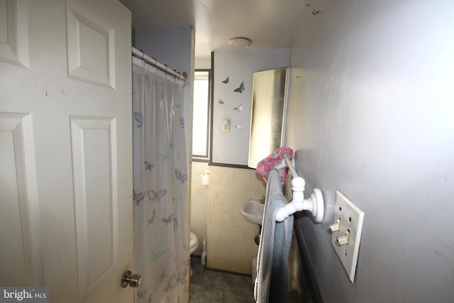 bathroom with a shower with curtain, tile patterned flooring, and toilet