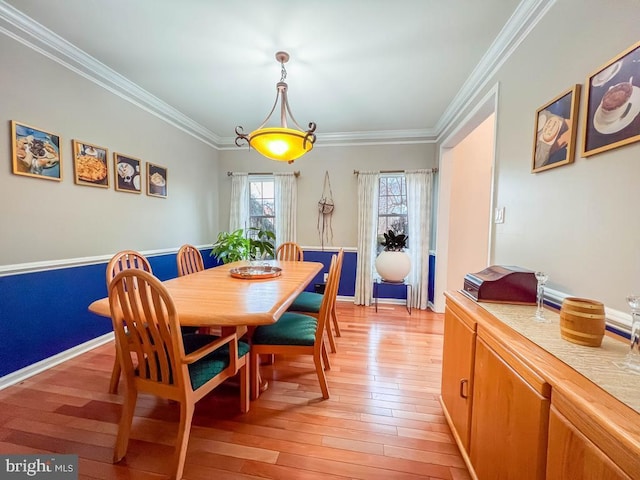 dining space with crown molding and light hardwood / wood-style flooring