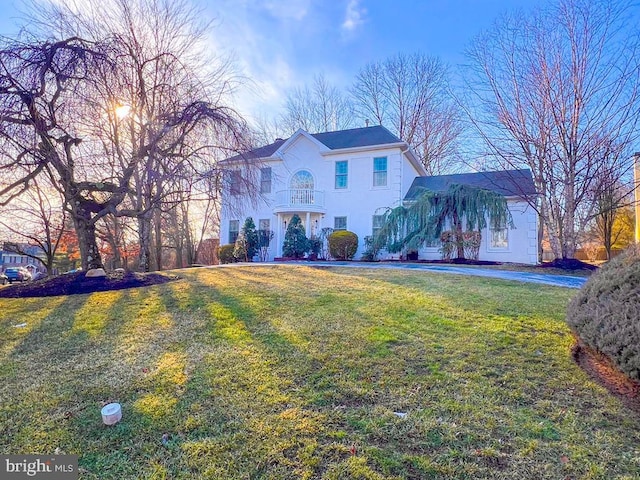 view of front of house featuring a balcony and a front yard