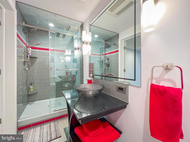 bathroom featuring sink and a shower with shower door