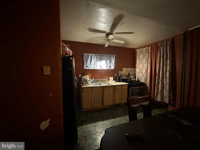 kitchen with ceiling fan, sink, stainless steel stove, and refrigerator