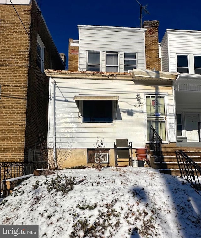 view of snow covered rear of property