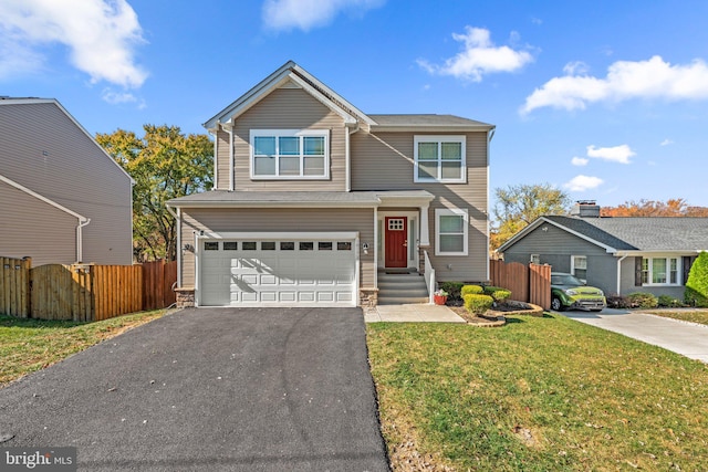 traditional-style home with aphalt driveway, a front lawn, fence, and an attached garage