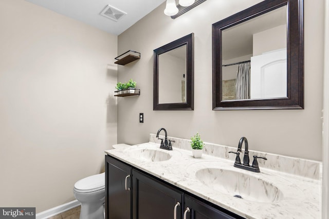 full bath featuring toilet, double vanity, a sink, and visible vents