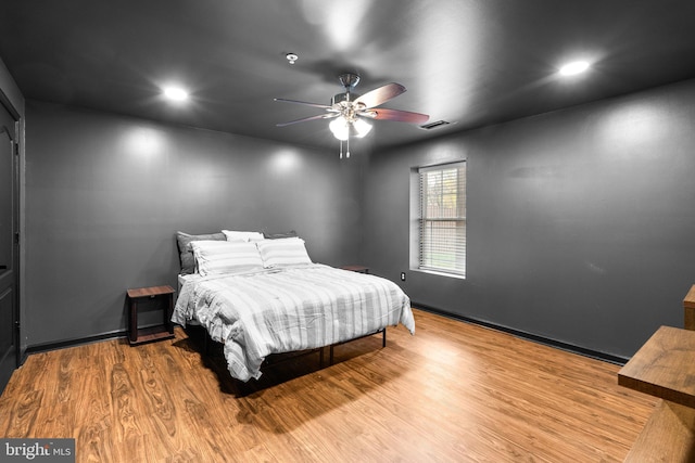 bedroom featuring recessed lighting, wood finished floors, a ceiling fan, baseboards, and visible vents