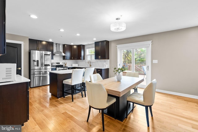 dining room with recessed lighting, light wood-type flooring, and baseboards