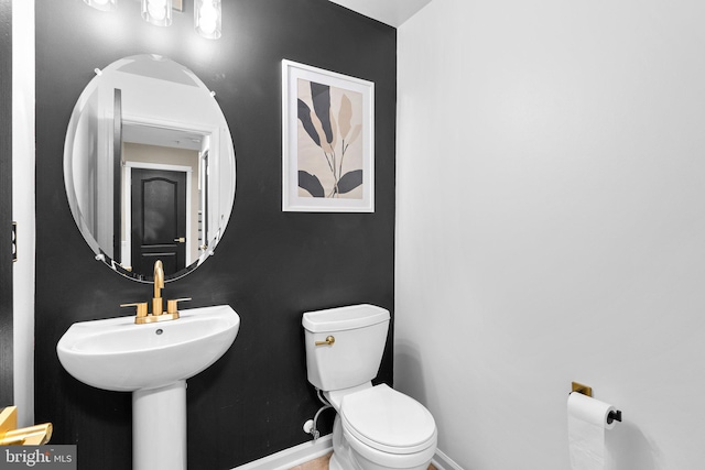 bathroom with toilet and baseboards