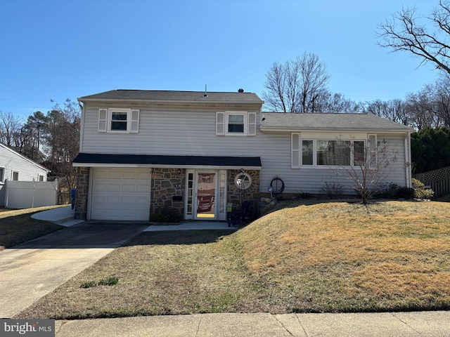 tri-level home featuring an attached garage, a front lawn, fence, stone siding, and driveway