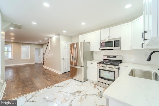 kitchen featuring white cabinetry, sink, decorative backsplash, and stainless steel appliances