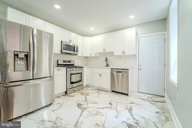 kitchen featuring white cabinetry, sink, tasteful backsplash, and appliances with stainless steel finishes