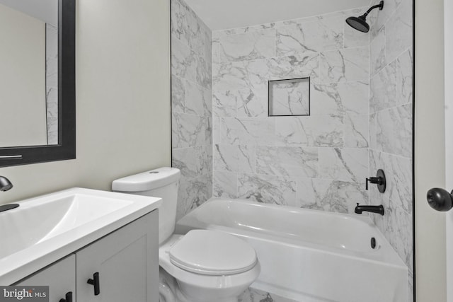 full bathroom with tiled shower / bath, vanity, and toilet